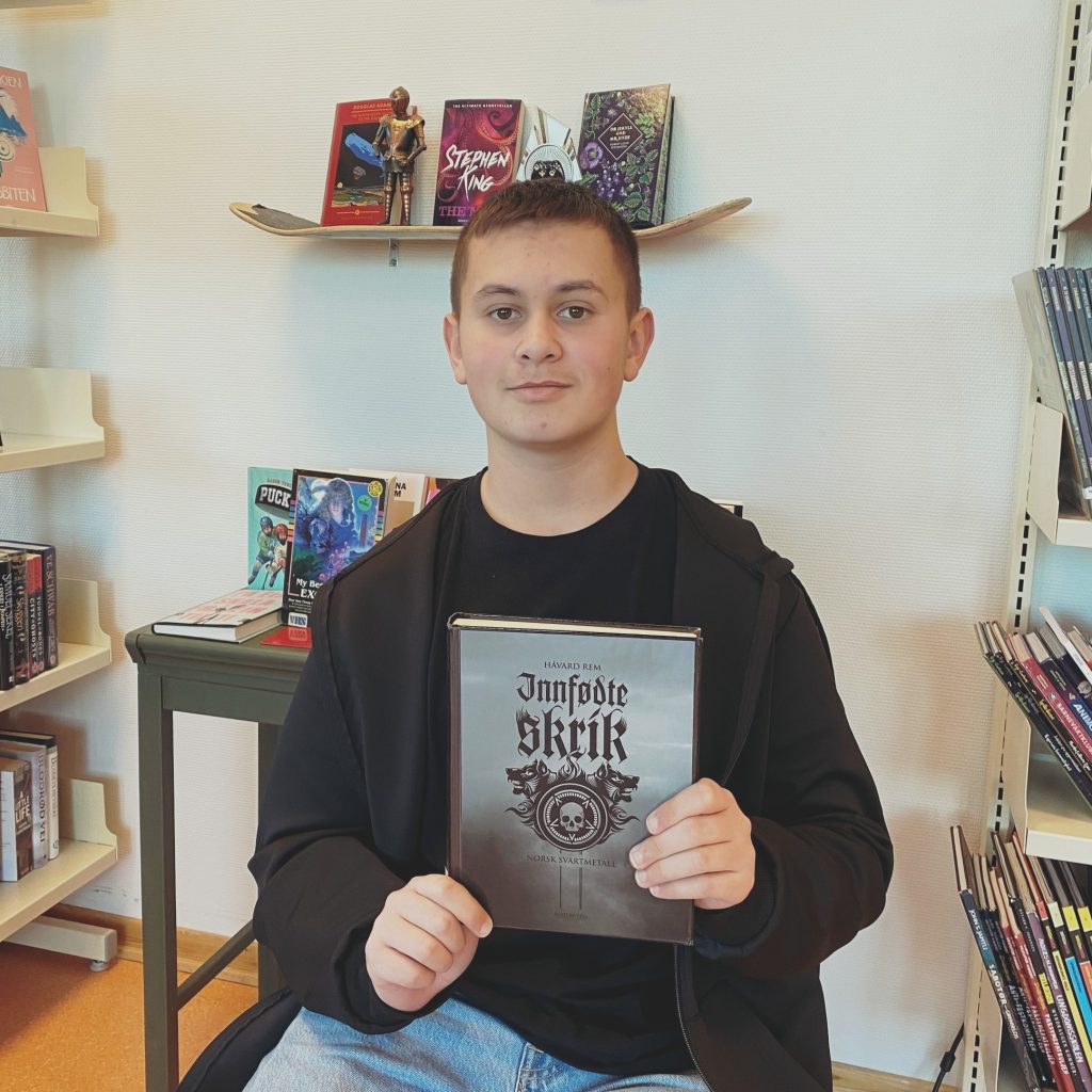 Leon viser frem boka "Innfødte Skrik"